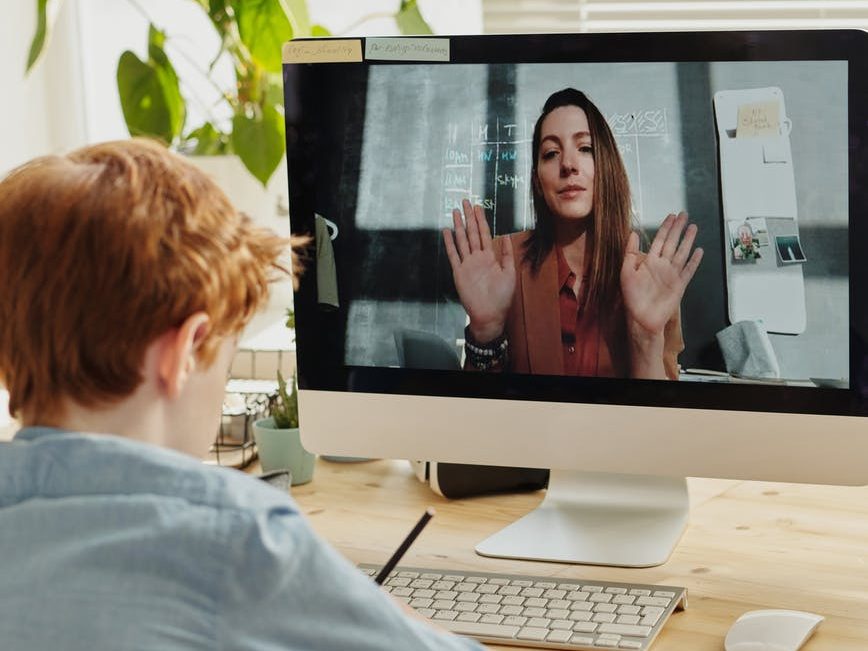 photo of boy video calling with a woman through imac